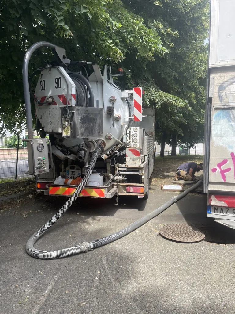 Camion hydrocureur avec flexibles déroulés vers un regard ouvert